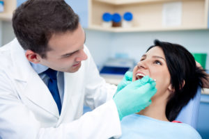 Dental implant specialist performing dental procedure on young woman