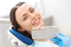 Lady in dentists chair choosing correct dental implant shades